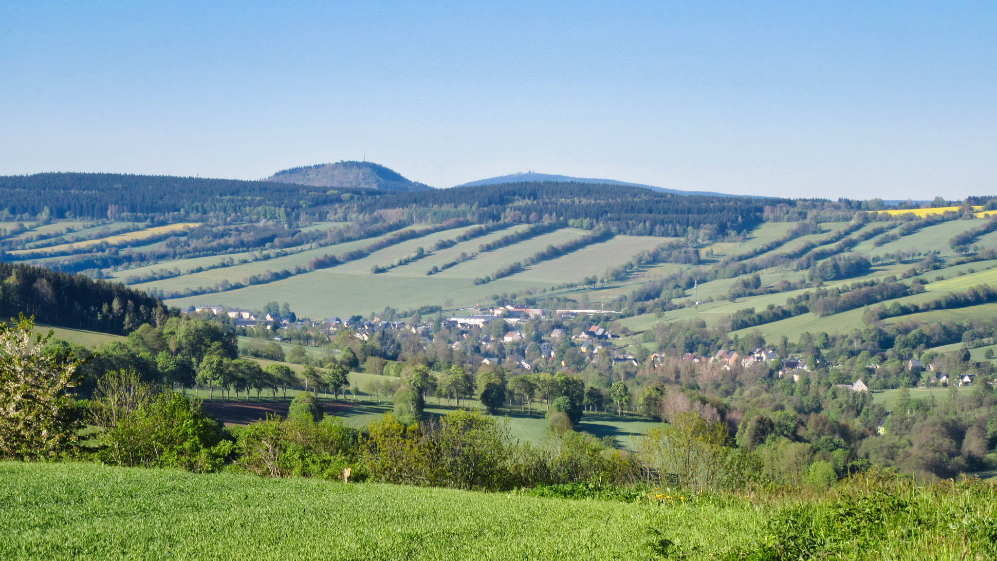 Königswalde, im Hintergrund der 898 Meter hohe Bärensteiner Berg (l.) und der 1.215 Meter hohe Fichtelberg. Foto: Chris Bergau